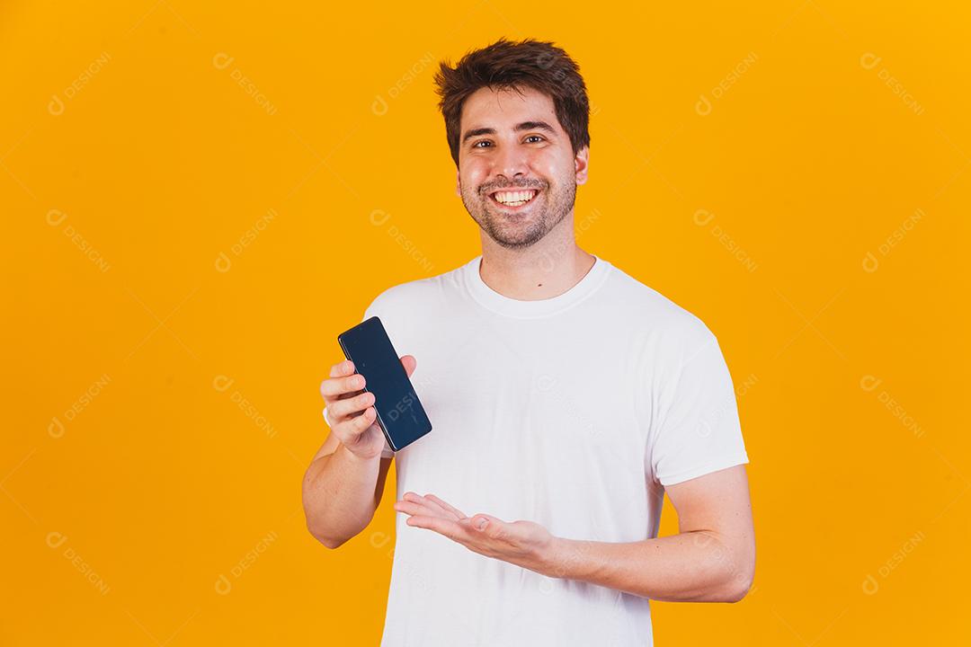 homem bonito com celular nas mãos apontando
