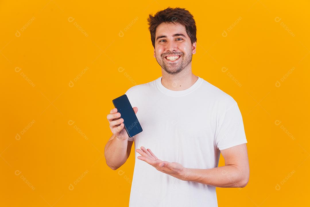 homem bonito com celular nas mãos apontando