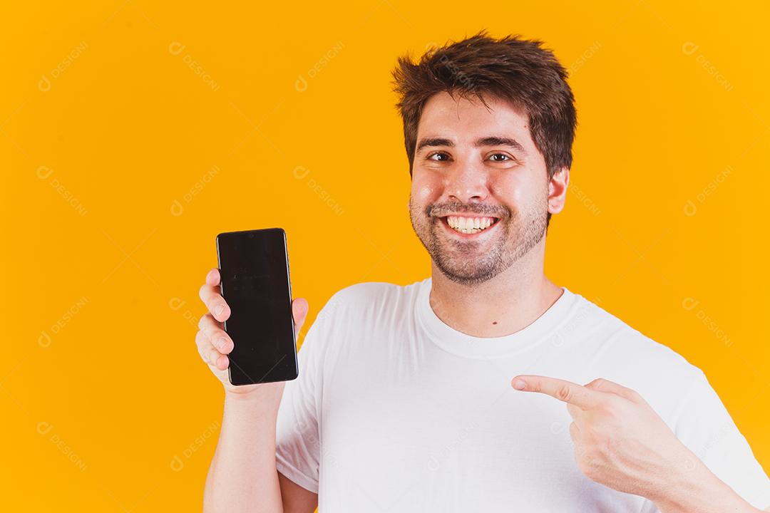 homem bonito com celular nas mãos apontando