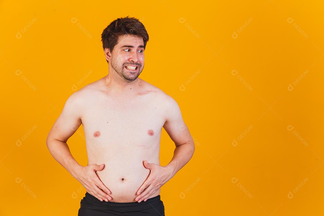 Homem tocando sua barriga gorda Mão de homem obeso segurando a gordura da barriga excessiva