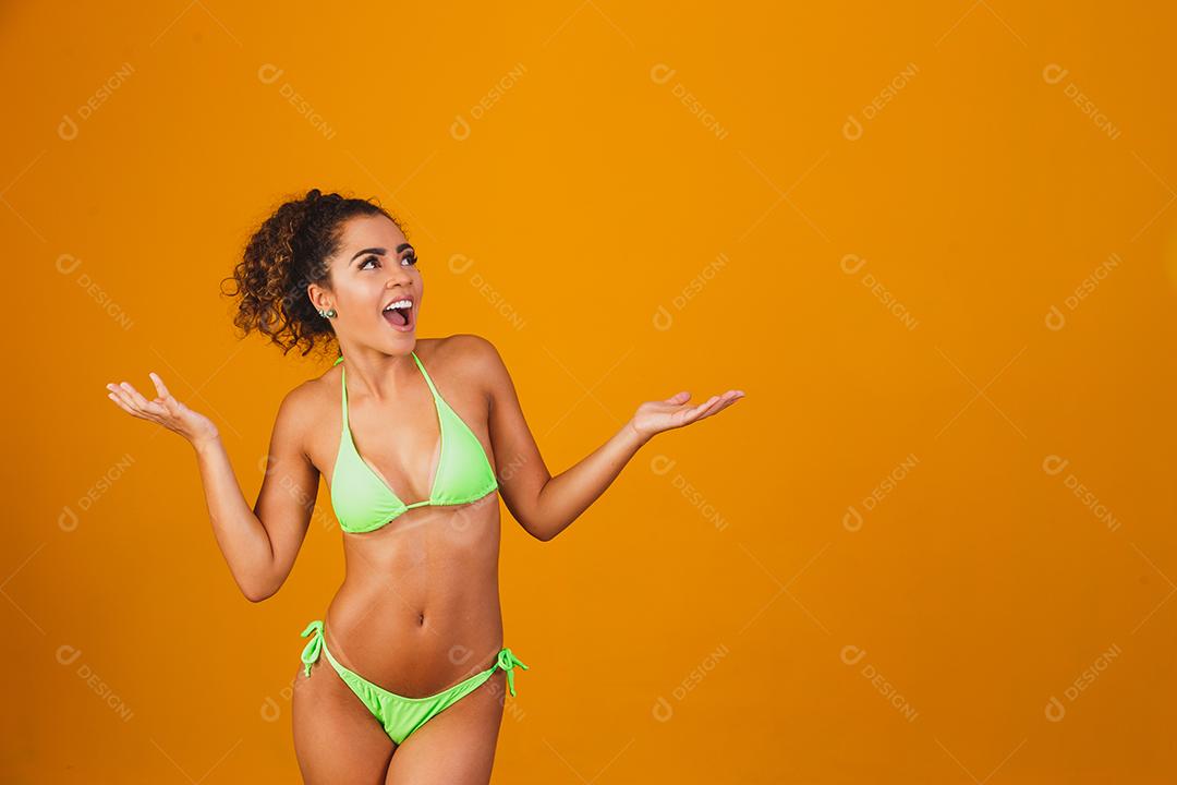 Mulher com roupa de praia biquini verde em fundo verde