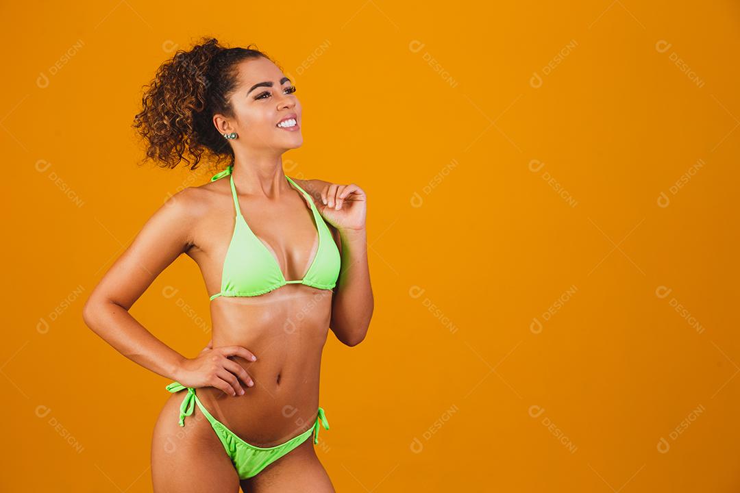 Mulher com roupa de praia biquini verde em fundo verde