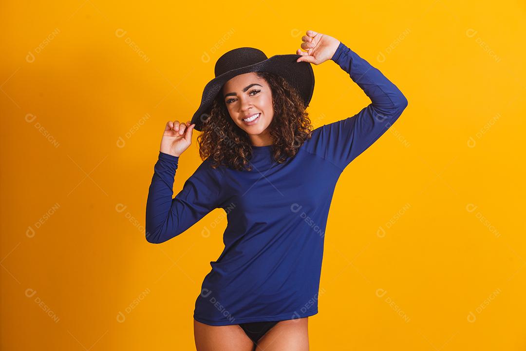 mulher afro com camiseta e chapéu de praia térmica