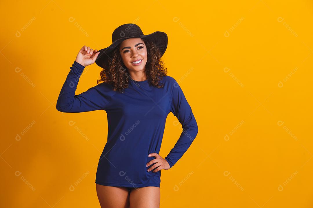mulher afro com camiseta e chapéu de praia térmica