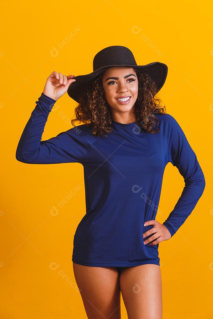 mulher afro com camiseta e chapéu de praia térmica