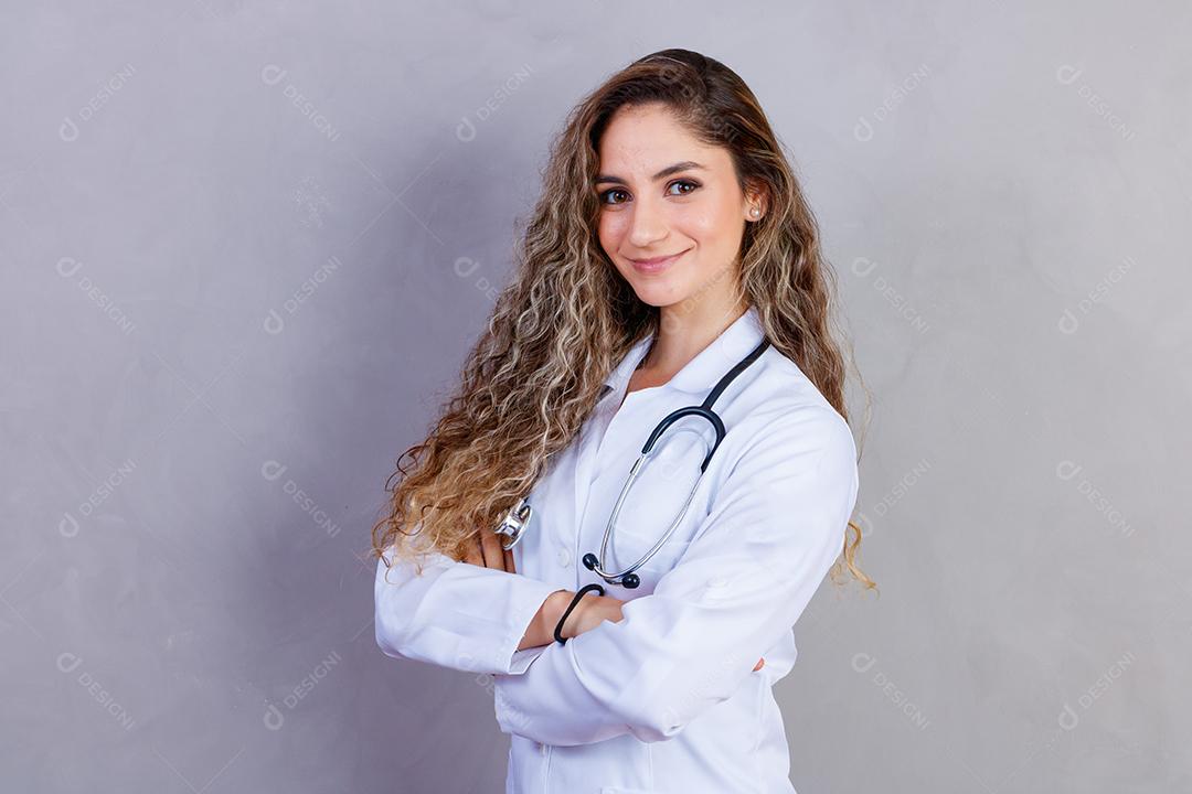 Mulher médica com jaleco e estetoscópio em fundo cinza