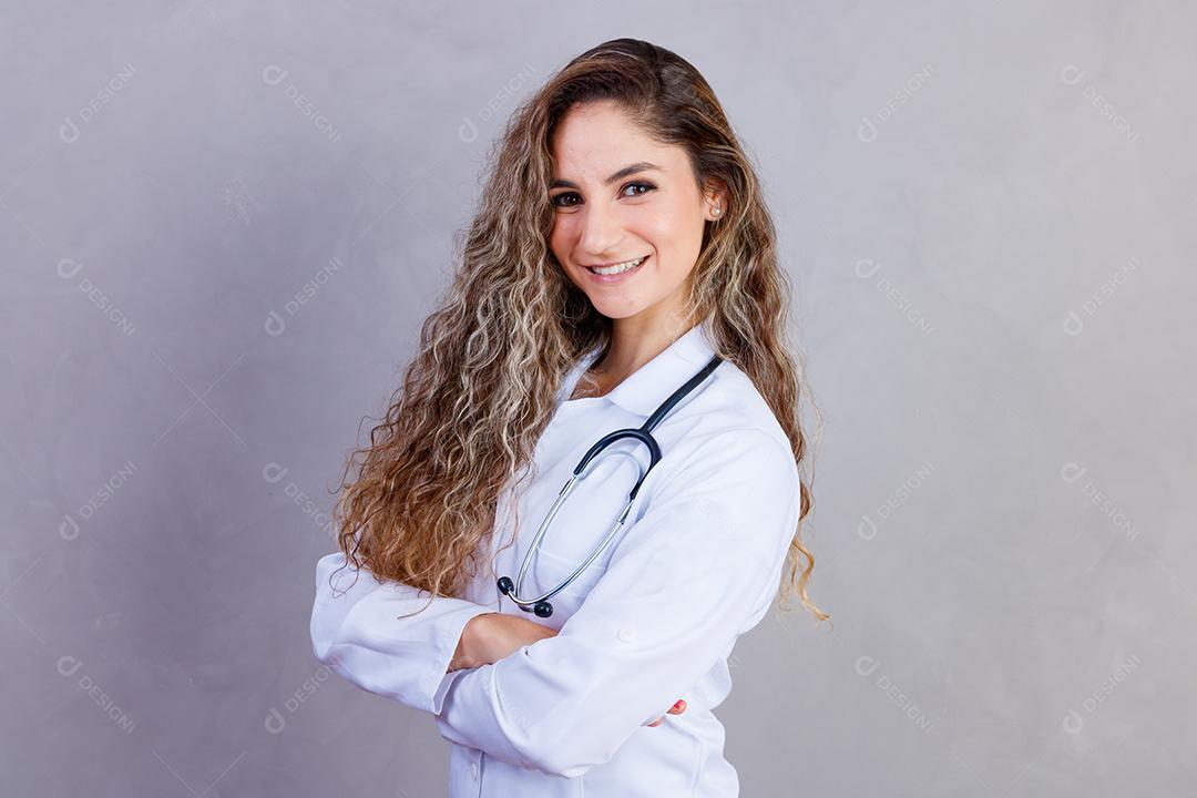 Mulher médica com jaleco e estetoscópio em fundo cinza