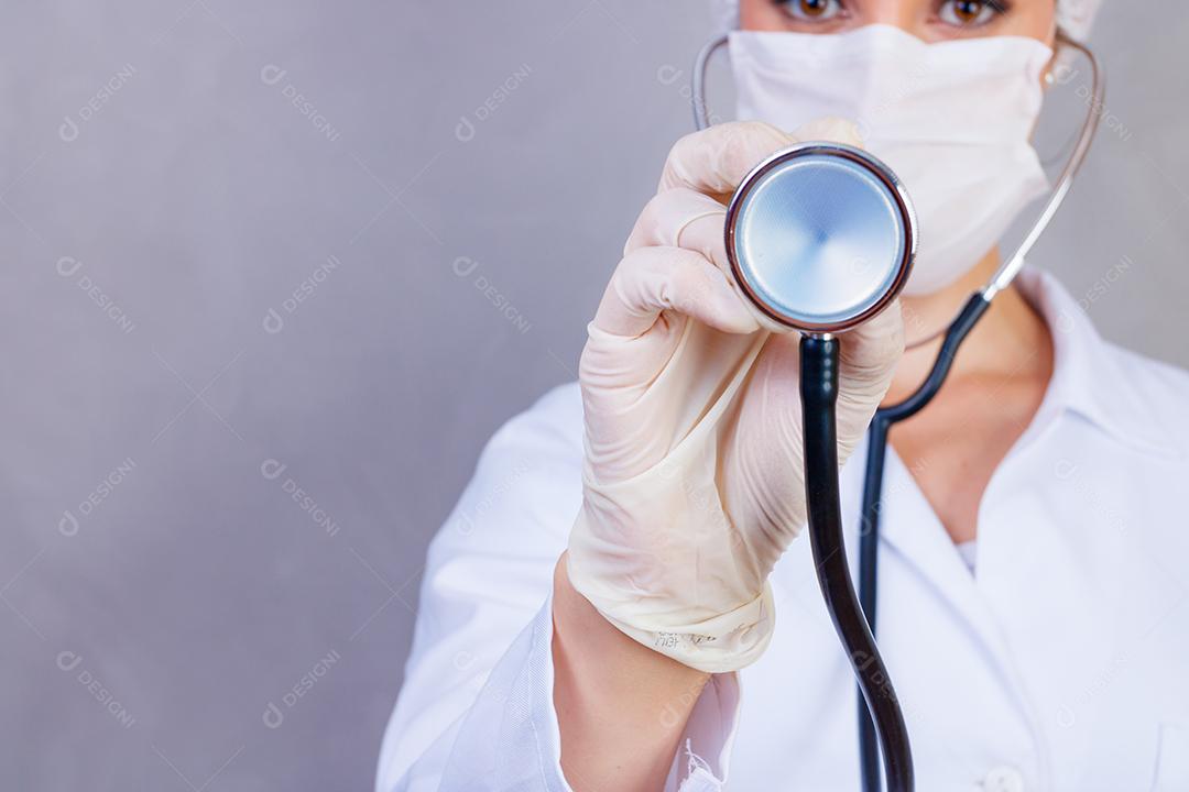 Mulher médica com jaleco e estetoscópio em fundo cinza