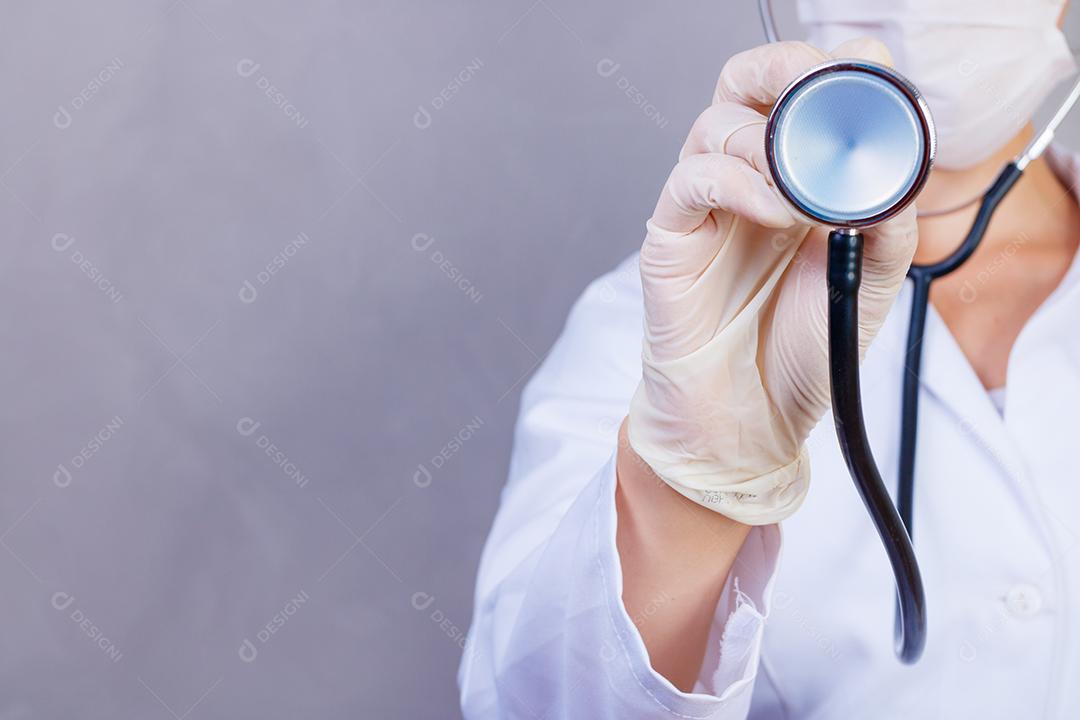 Mulher médica com jaleco e estetoscópio em fundo cinza