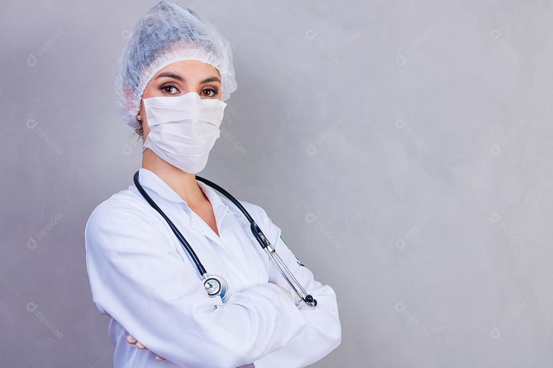 Mulher médica com jaleco e estetoscópio em fundo cinza