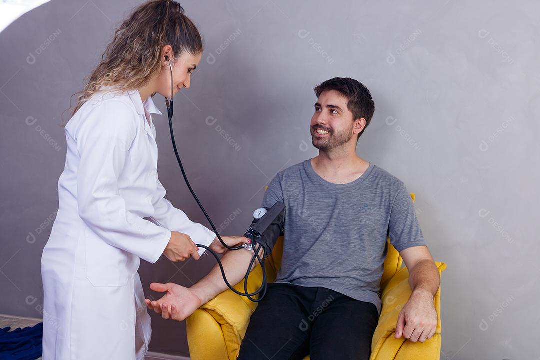 Mão do médico medindo a pressão arterial do paciente do sexo masculino