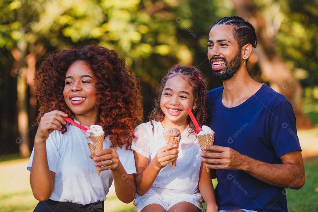 família afro no parque tomando sorvete