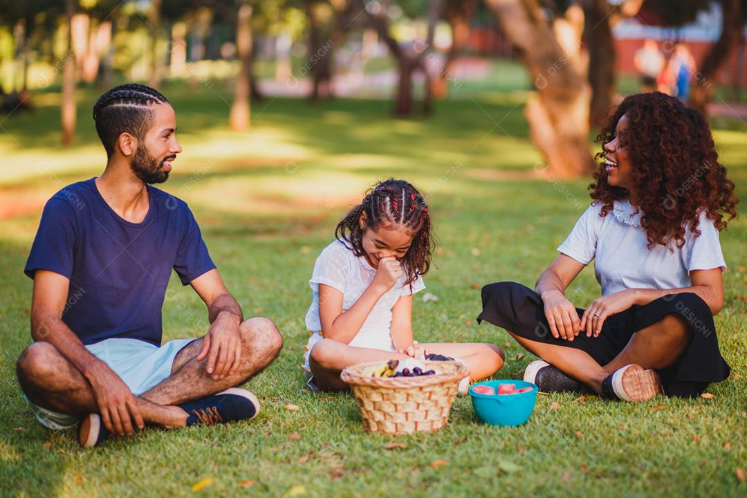 Família feliz fazendo piquenique no parque