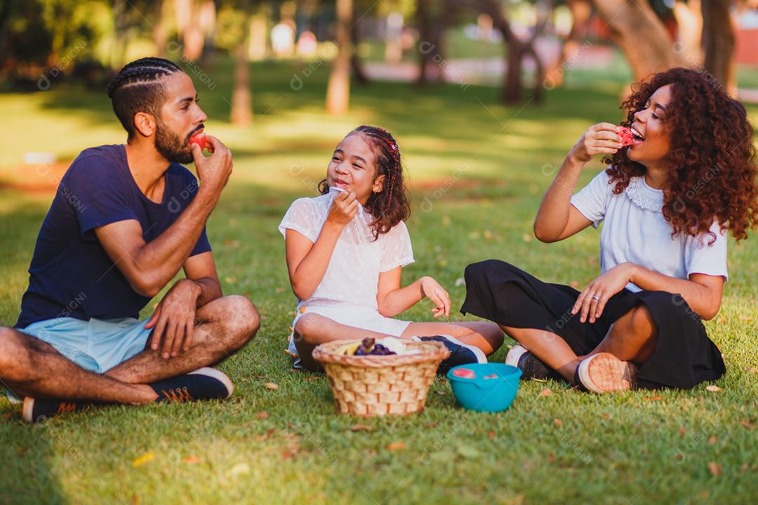 Família feliz fazendo piquenique no parque