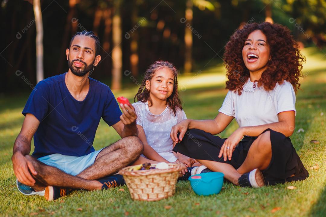 Família feliz fazendo piquenique no parque