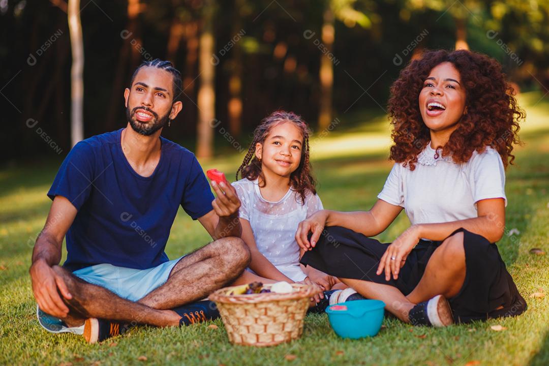 Família feliz fazendo piquenique no parque