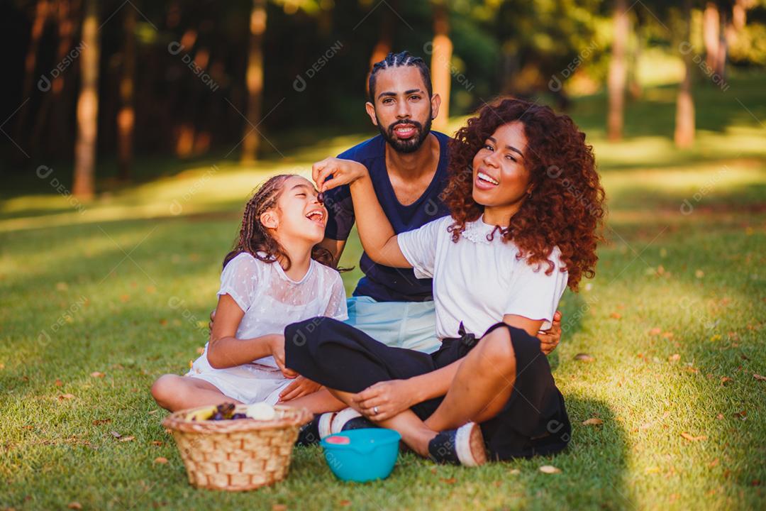 Família feliz fazendo piquenique no parque