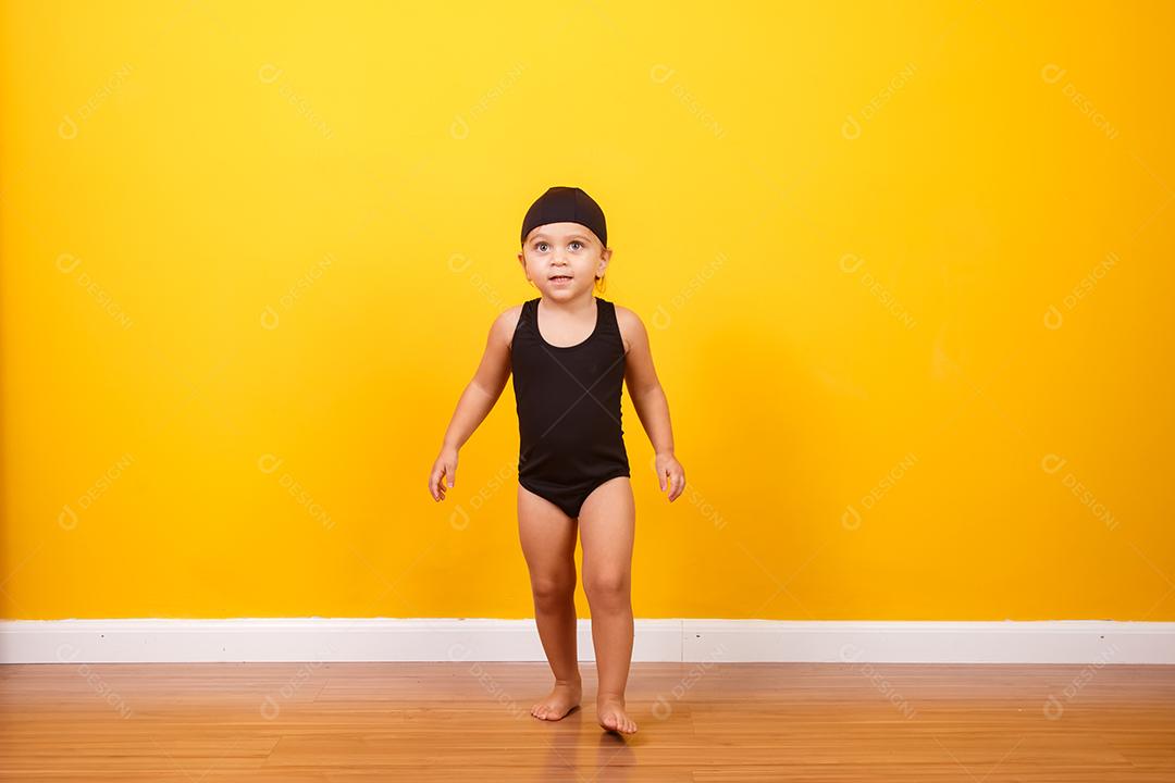 Menina vestindo roupa de praia em fundo amarelo. Conceito de verão e férias