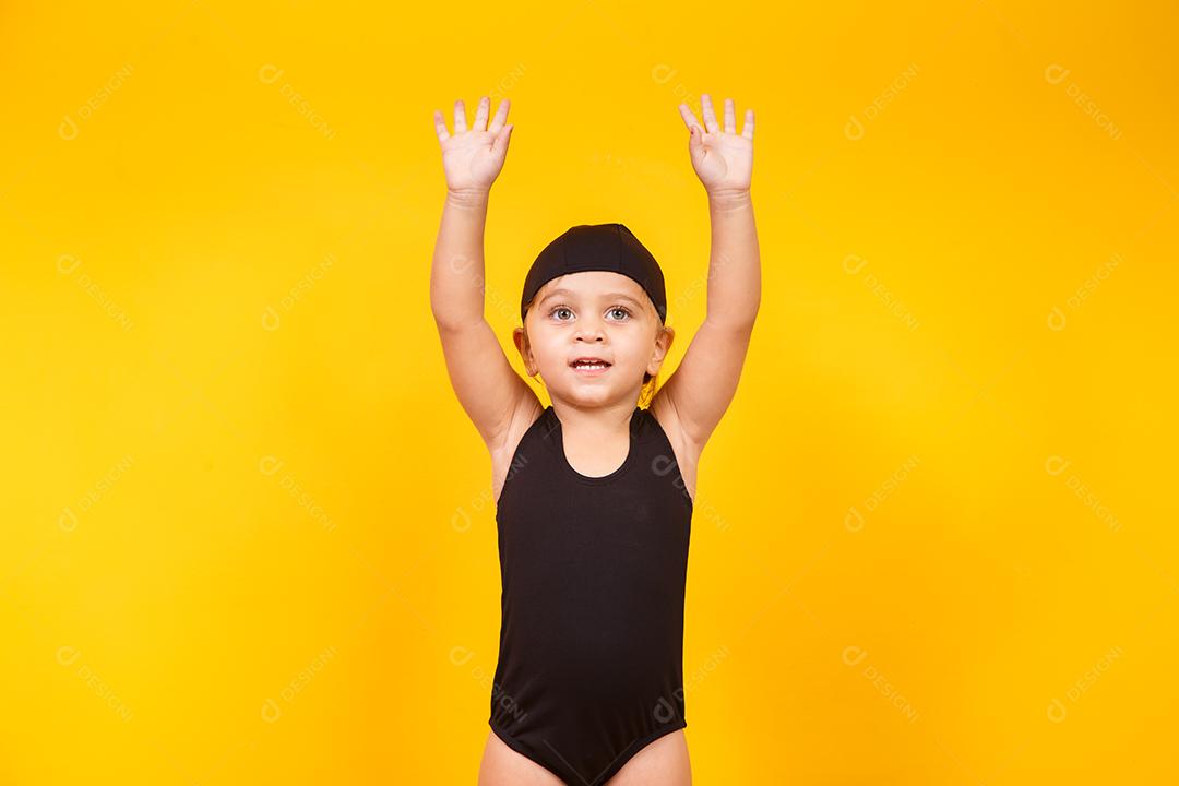 Menina vestindo roupa de praia em fundo amarelo. Conceito de verão e férias