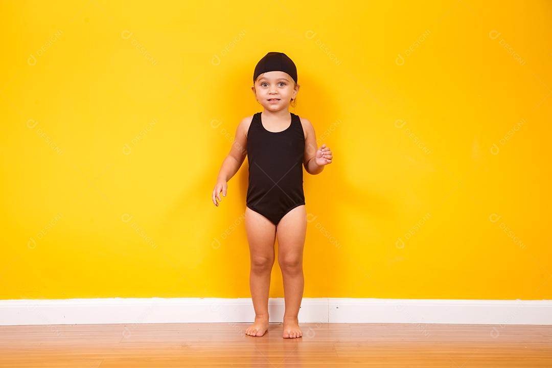 Menina vestindo roupa de praia em fundo amarelo. Conceito de verão e férias