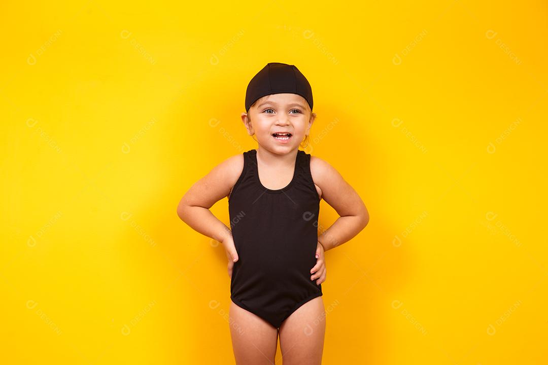 Menina vestindo roupa de praia em fundo amarelo. Conceito de verão e férias