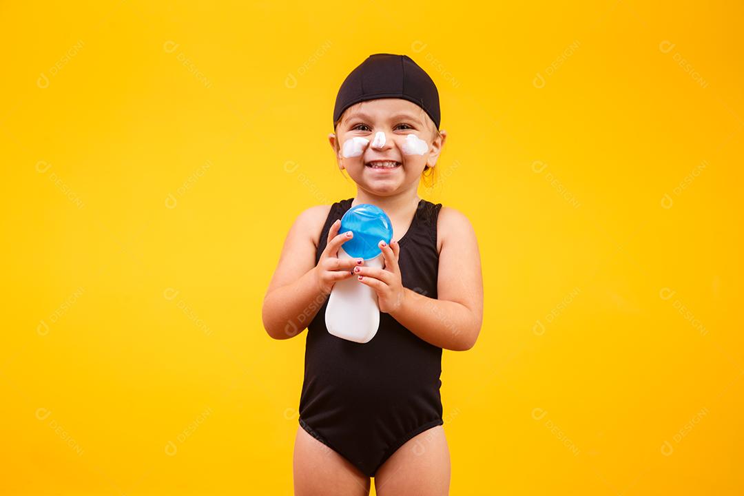 Menina com maiô de natação e protetor solar.