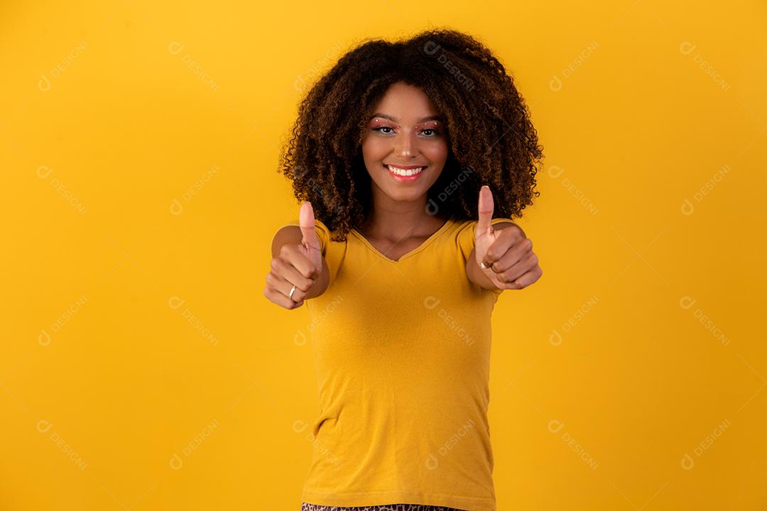 Retrato de sorrir bela jovem afro polegares para cima. menina brasileira.