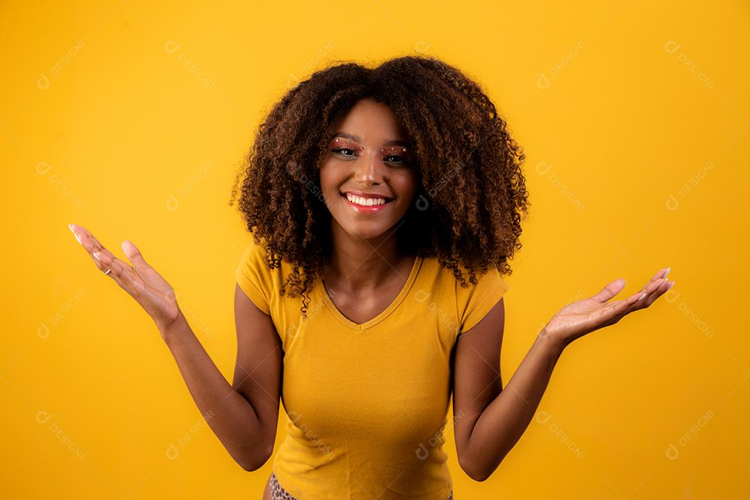 Linda garota afro com cabelo encaracolado, apontando para o lado