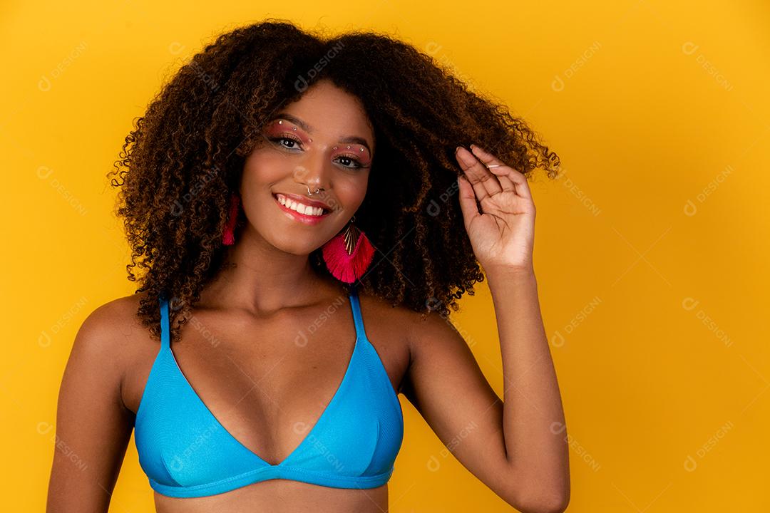 Linda garota afro com cabelo encaracolado e sorriso de biquíni para a câmera