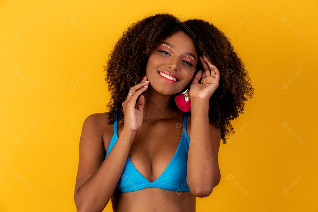 Linda garota afro com cabelo encaracolado e sorriso de biquíni para a câmera