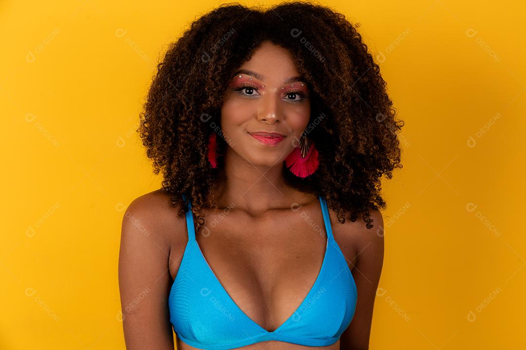 Linda garota afro com cabelo encaracolado e sorriso de biquíni para a câmera