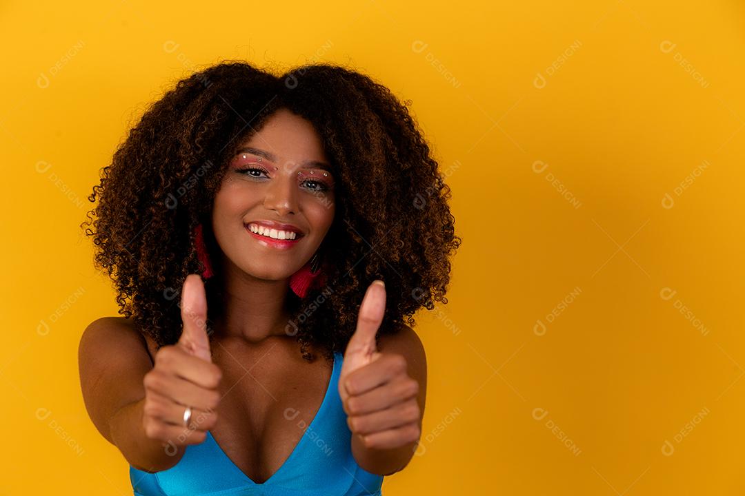 Retrato de sorrir bela jovem afro polegares para cima. menina brasileira.