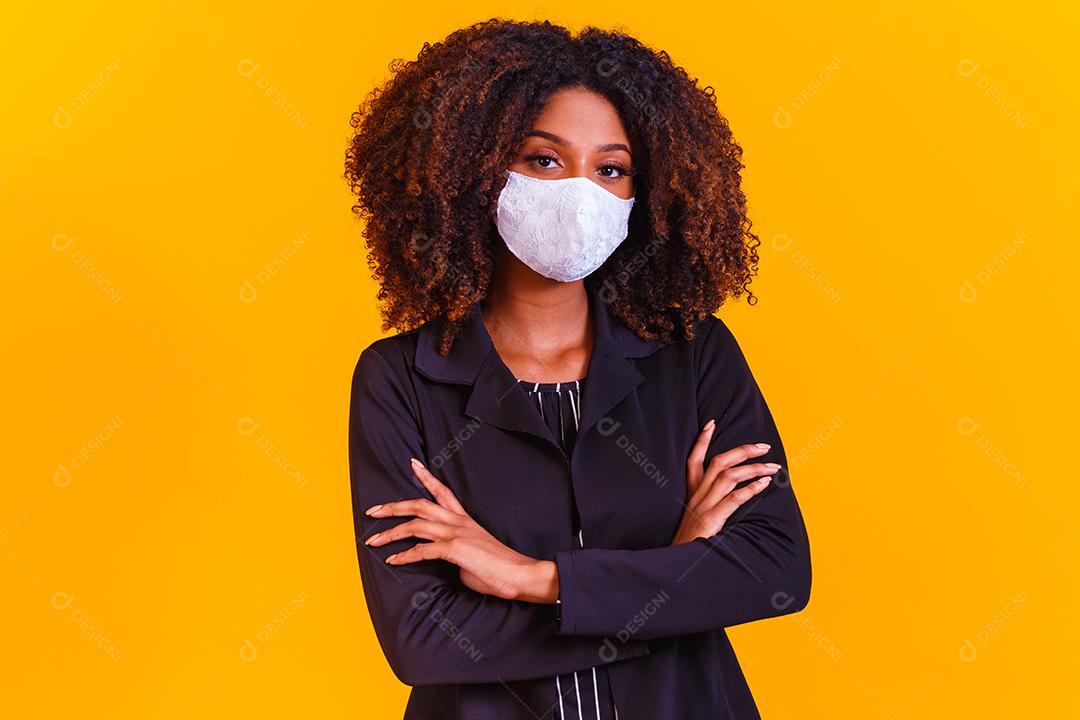 jovem modelo negro usando máscara protetora. Linda garota negra com cabelo grande, usando máscara protetora branca.