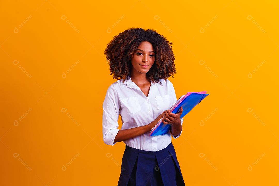 Mulher estudante afro com livros e cadernos nas mãos