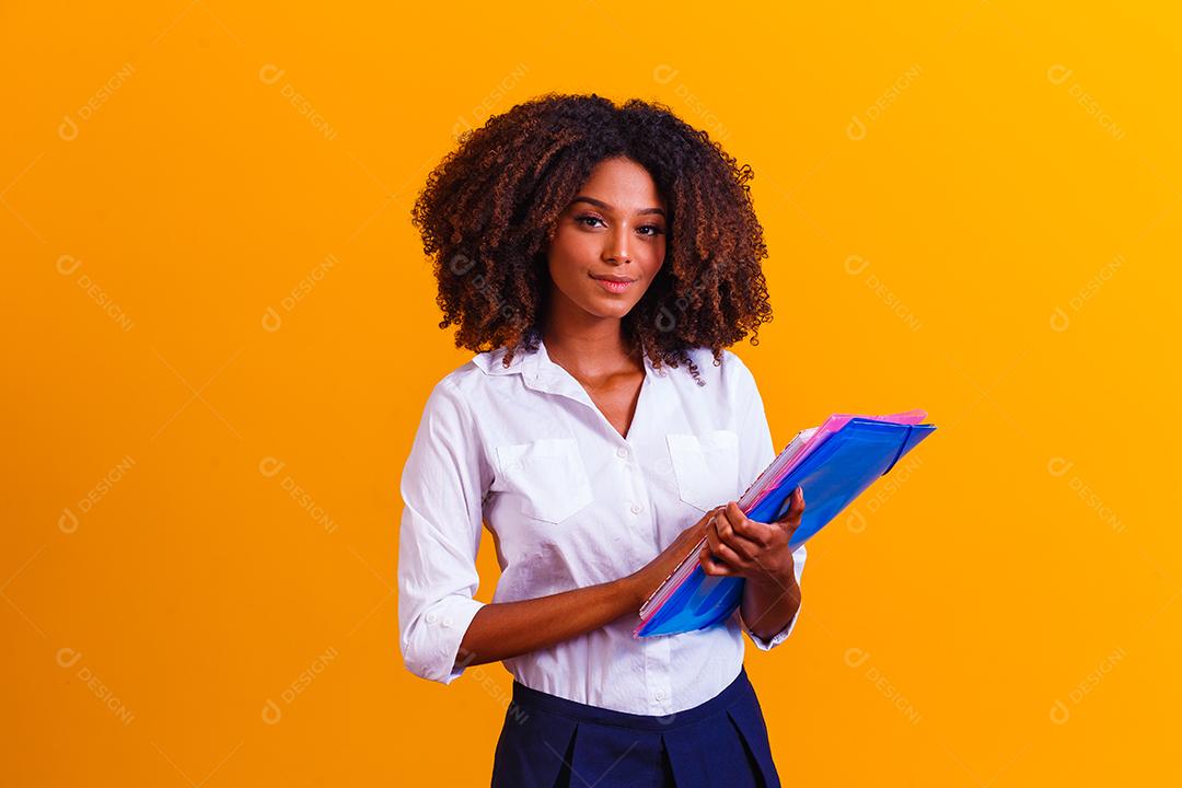 Mulher estudante afro com livros e cadernos nas mãos