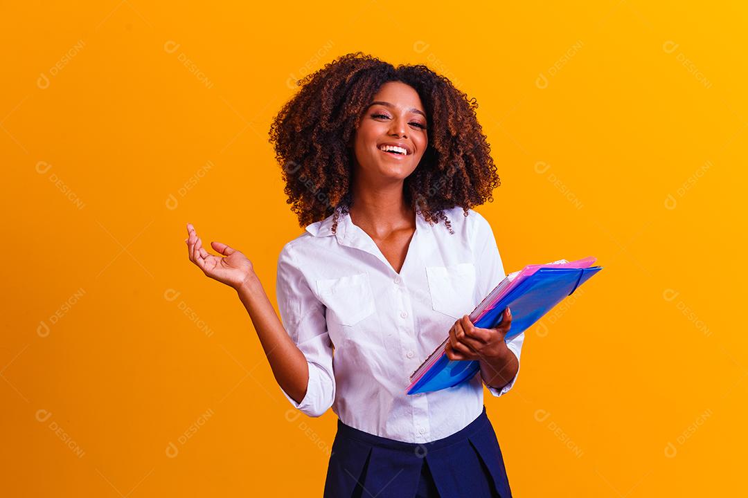 Mulher estudante afro com livros e cadernos nas mãos