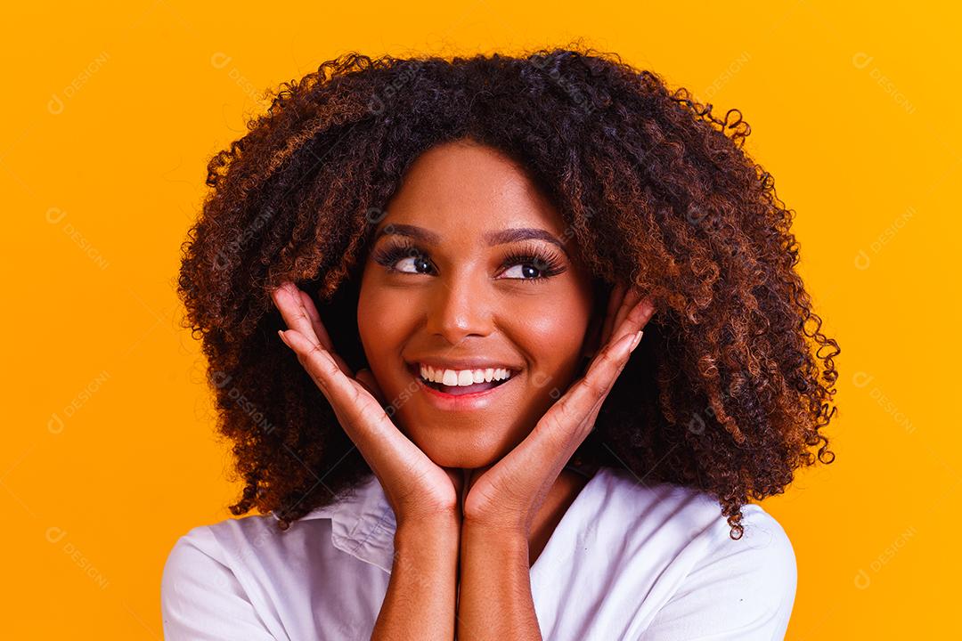 Mulher morena sorrindo em fundo amarelo