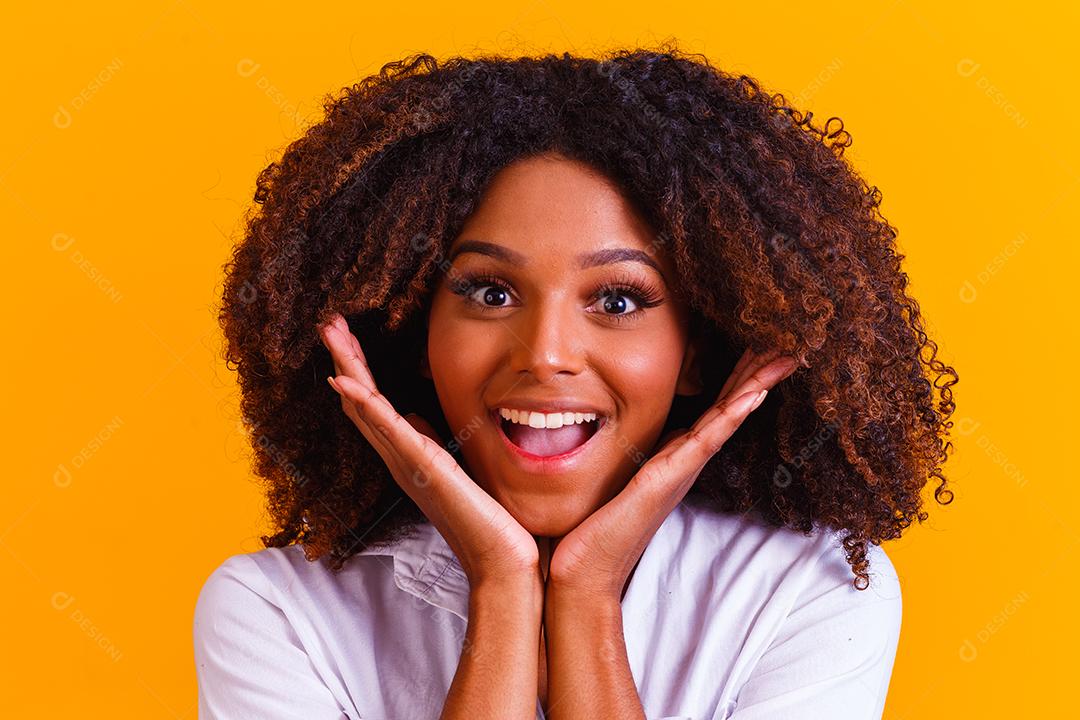 Mulher morena sorrindo em fundo amarelo