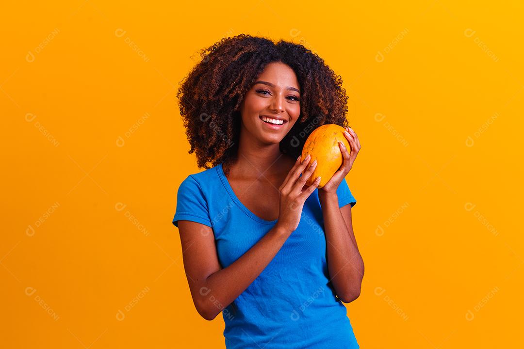 Young beautiful woman holding papaya over isolated yellow background