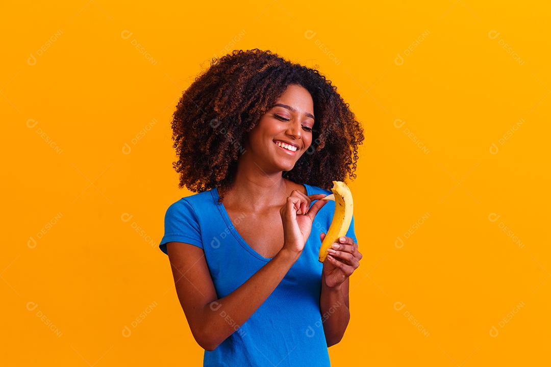 Mulher morena sorrindo segurando verduras em fundo amarelo