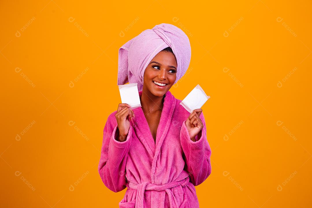 Linda Mulher Afro com Toalha na Cabeça e Roupão de Banho segurando sabonetes