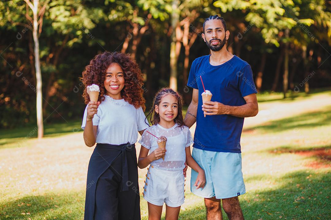 família afro no parque tomando sorvete
