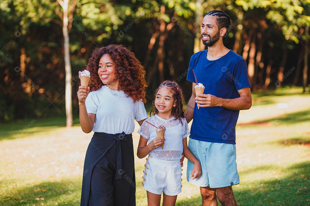 família afro no parque tomando sorvete