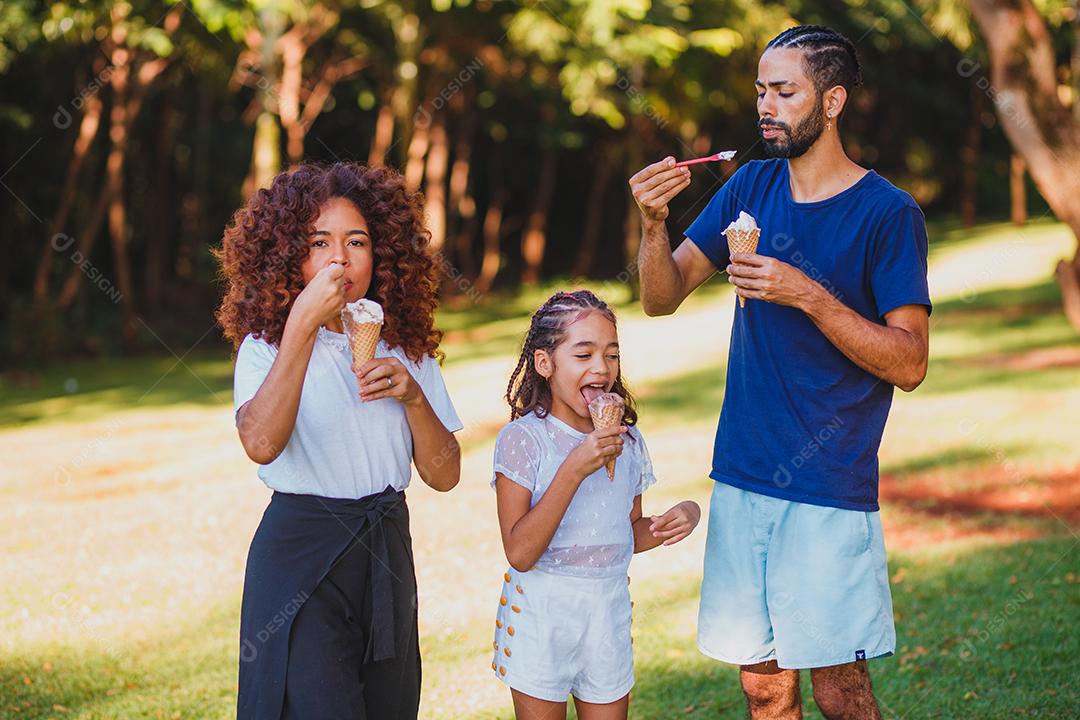 família afro no parque tomando sorvete