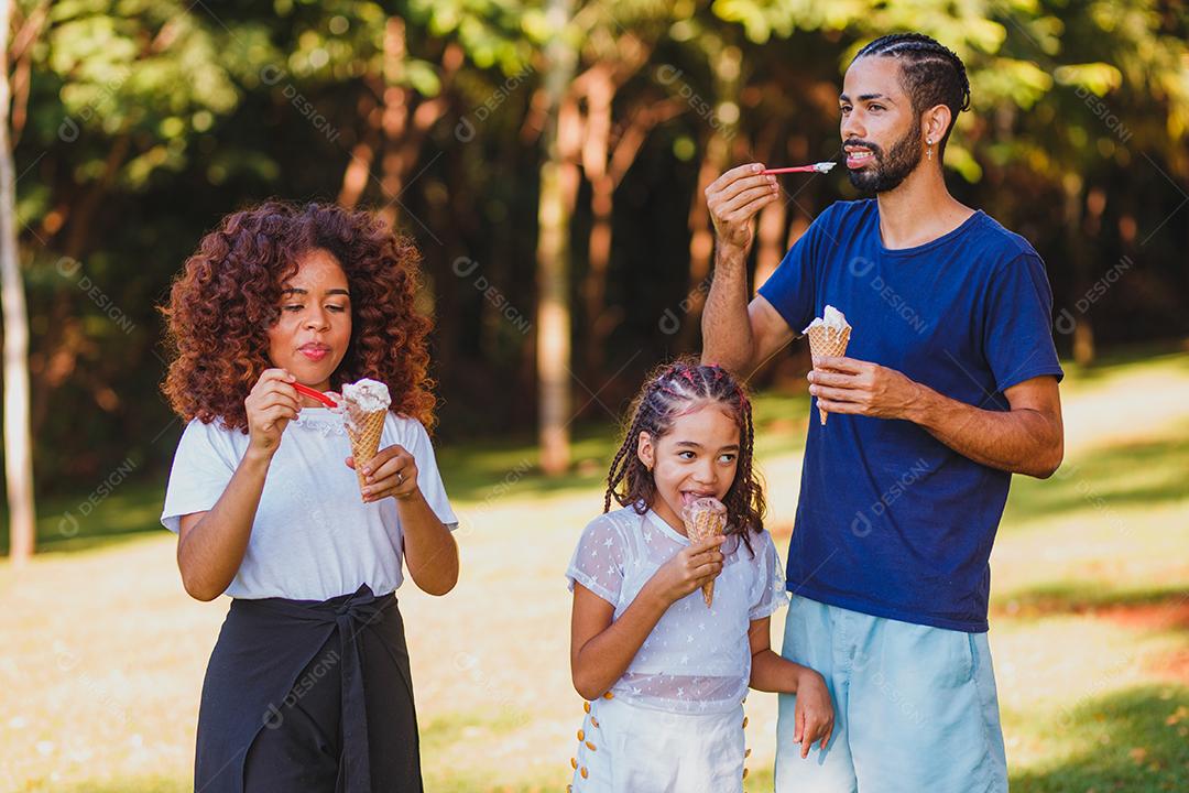 família afro no parque tomando sorvete