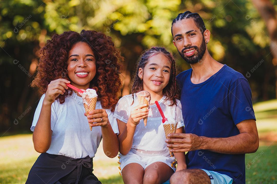 família afro no parque tomando sorvete