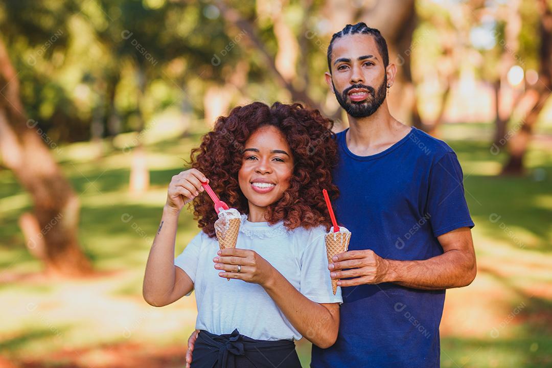 família afro no parque tomando sorvete