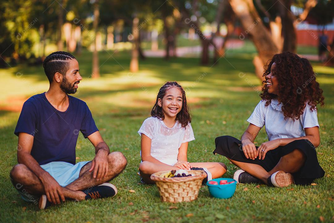 Família feliz fazendo piquenique no parque