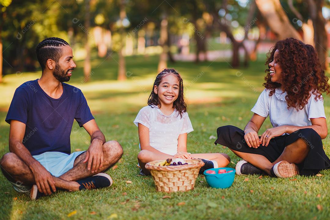 Família feliz fazendo piquenique no parque