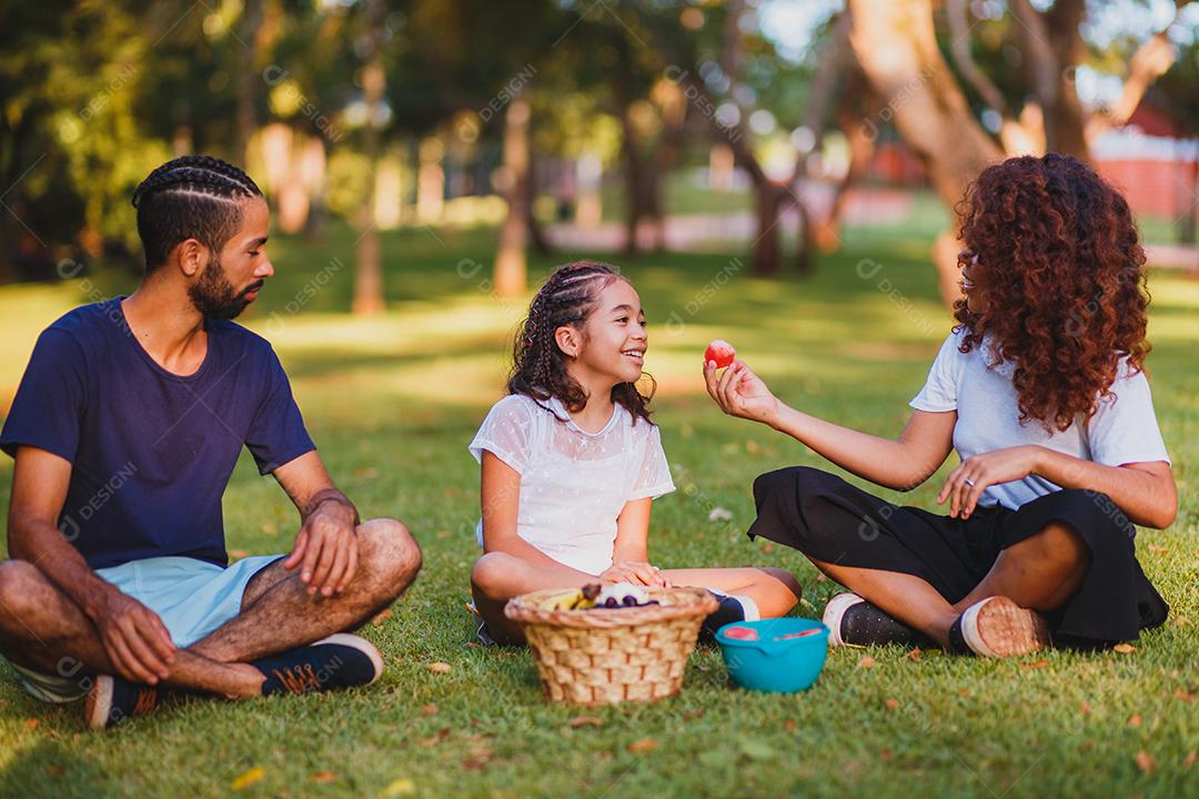 Família feliz fazendo piquenique no parque